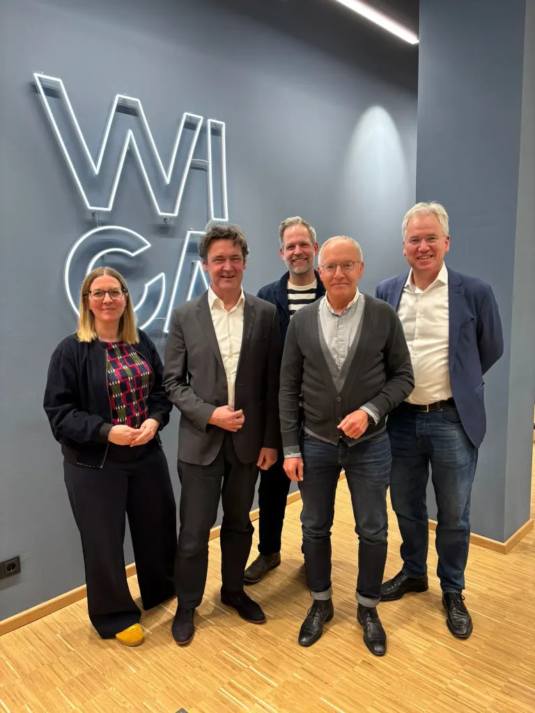 Gruppenfoto von fünf Personen vor dem leuchtenden WICA-Schriftzug