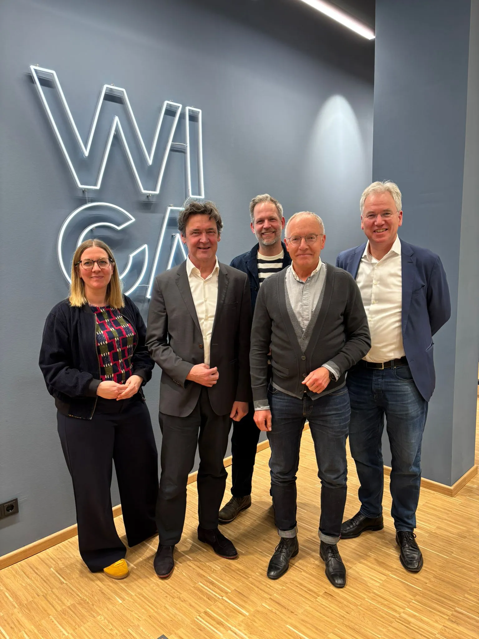 Gruppenfoto von fünf Personen vor dem leuchtenden WICA-Schriftzug