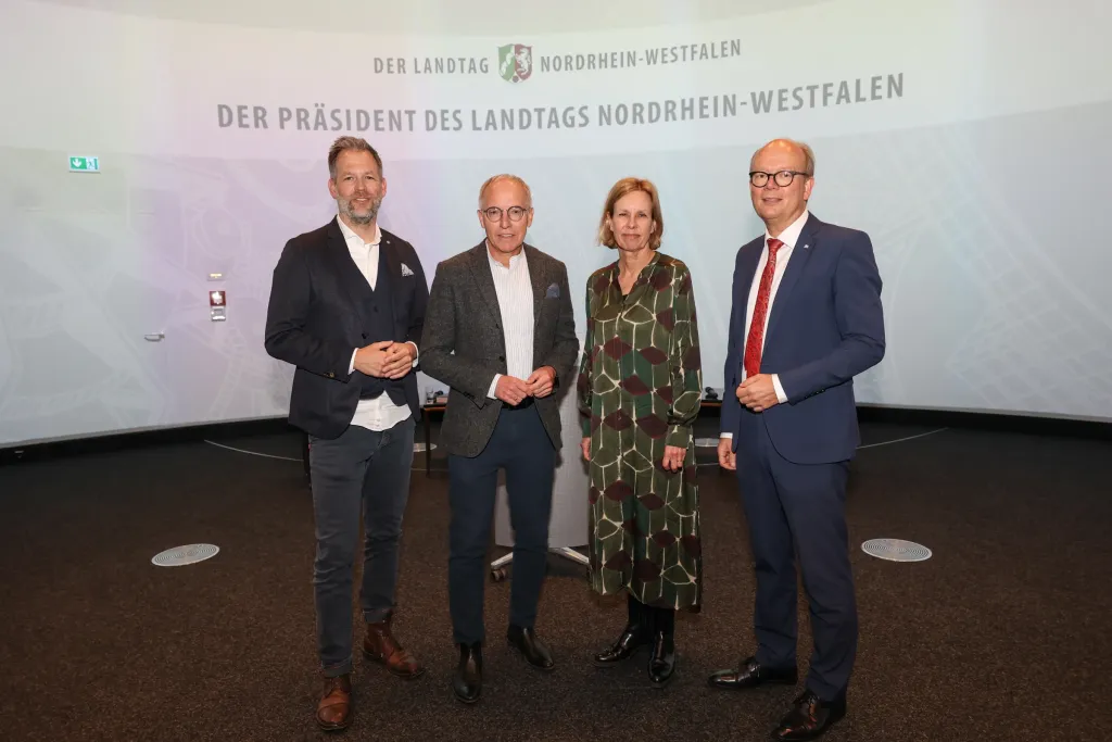 Gruppenfoto von vier Personen unter dem Schriftzug Der Präsident des Landtags Nordrhein-Westfalen