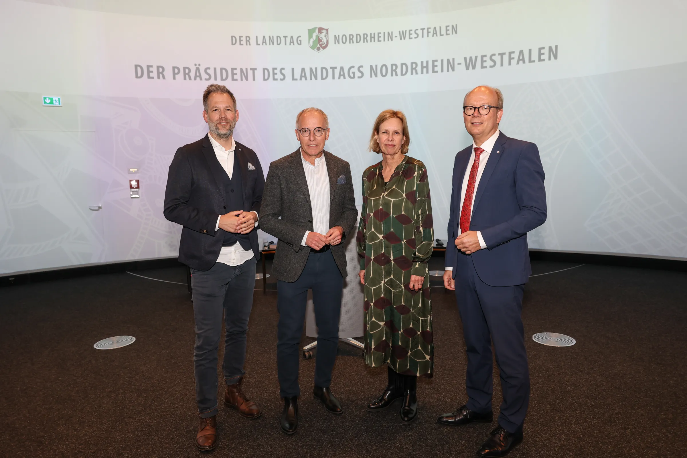 Gruppenfoto von vier Personen unter dem Schriftzug Der Präsident des Landtags Nordrhein-Westfalen